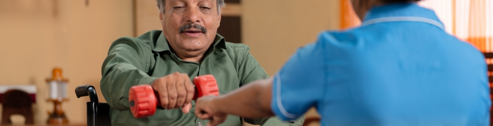 An elderly taking physiotherapy with a caretaker