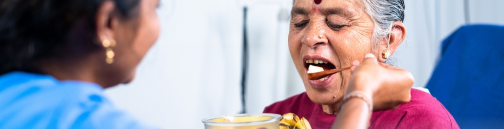 A Caretaker Feeding an Elderly